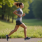 A runner on a scenic outdoor path captured mid run in profile view focusing on perfect running form The runner has an upright posture with their head facing forward and shoulders relaxed Thei